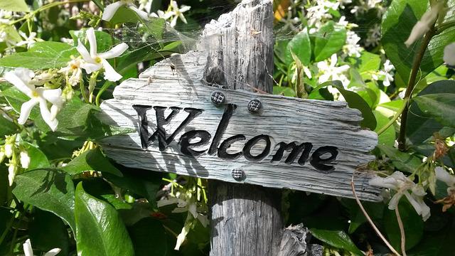 A welcome sign between some leaves which indicates a specific direction